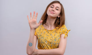 Young woman showing five fingers to represent appetite control tips