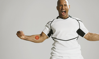 Athletic man flexing with an Energy Patch visible on his arm, representing steady daytime energy support.