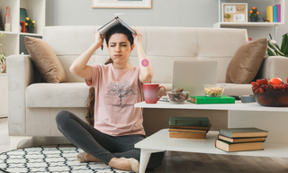 Woman indoors with a wellness patch on her arm, representing mental fatigue and inconsistent motivation.