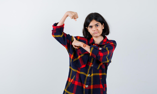 Person showing strength and energy by flexing their arm, representing increased energy levels, physical wellness, and healthy lifestyle habits.