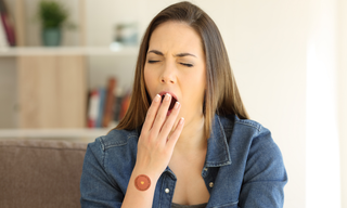 Woman yawning in the afternoon, illustrating the common 2pm energy slump and daytime fatigue.
