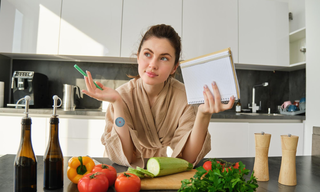 Woman preparing fibre-rich foods such as vegetables to support digestive health and appetite control.