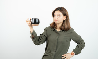 Woman questioning her coffee choice, representing natural energy vs caffeine and the impact of energy crashes.