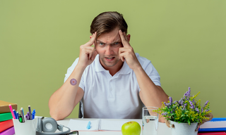 Man experiencing mental stress and cognitive overload at his desk, representing stress management, mental wellbeing, focus, and emotional health.