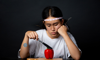 Woman struggling with food cravings during dieting, illustrating appetite control and low hunger patches