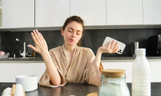 Woman wearing a wellness patch while using a smartphone, highlighting skin absorption and a daily skincare routine.