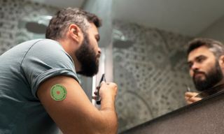 Man applying his morning grooming routine while wearing a transdermal wellness patch, representing wellness patches, healthy lifestyle choices, and alternative supplement delivery methods.